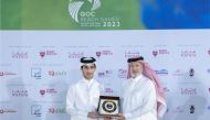 Qatar Olympic Committee First Vice President Mohamed bin Yousef Al Mana presents a memento to a participant.