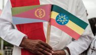 In this file photo taken on November 09, 2018 a man holds National flags of Eritrea (left) and Ethiopia as he waits for the arrival of Eritrea's President at the airport in Gondar, nothern Ethiopia.  (Photo by EDUARDO SOTERAS / AFP)