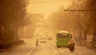 People commute on a street during a sandstorm in Jilin, in China's northeastern Jilin province on March 22, 2023. (Photo by AFP) / China OUT
