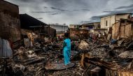 A boy stands in the remains of a burnt house in a residential area in Plumpang, north Jakarta on March 4, 2023, after a fire at a nearby state-run fuel storage depot run by energy firm Pertamina. (Photo by ADITYA AJI / AFP)

