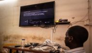 A man watches a television showing the cut signal of the France 24 channel, hours after the ruling junta in Burkina Faso decided to suspend the channel, in Ouagadougou, on March 27, 2023. 
(Photo by OLYMPIA DE MAISMONT / AFP)
 