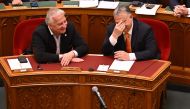 Hungarian Prime Minister Viktor Orban (right) and deputy prime minister Zsolt Semjen share a laugh as they attend the parliamenary session prior to the voting of representatives of the Hungarian Parliament about Finland's NATO accession, in the main hall of the parliament building in Budapest on March 27, 2023. (Photo by Attila Kisbenedek / AFP)