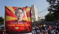 In this file photo taken on February 15, 2021 a banner featuring Aung San Suu Kyi is displayed as protesters take part in a demonstration against the military coup in front of the National League for Democracy (NLD) office in Yangon.  (Photo by AFP)