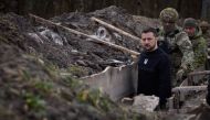 This handout photograph taken and released by Ukrainian Presidential Press Service on March 28, 2023 shows President Volodymyr Zelensky walking along tranches with border guard officers as he inspects the state border with Russian Federation in Sumy region. (Photo by Handout / Ukrainian Presidential Press Service / AFP)