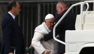 Pope Francis is helped get up the popemobile car as he leaves on March 29, 2023 at the end of the weekly general audience at St. Peter's square in The Vatican. (Photo by Vincenzo PINTO / AFP)