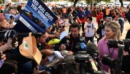 Red Bull Racing's Australian reserve driver Daniel Ricciardo signs autographs to fans ahead of the first practice session of the 2023 Formula One Australian Grand Prix at the Albert Park Circuit in Melbourne on March 31, 2023. Photo by Paul CROCK / AFP