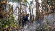 A member of the fire and rescue team attends to a forest fire on a mountain-side in Nakhon Nayok province, northeast of Bangkok on March 31, 2023. Photo by Jack TAYLOR / AFP