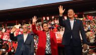 Thai candidates for prime minister Paetongtarn Shinawatra (C), Srettha Thavisin (R) and Chaikasem Nitisiri (L) wave to the crowd during an election rally for Thailand's main opposition Pheu Thai party at the Thunder Dome Stadium in Nonthaburi, north of the capital Bangkok, on April 5, 2023. (Photo by Jack Taylor / AFP)
 