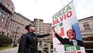 A man sets up a banner reading 