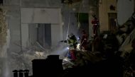 Emergency service personnel look into the rubble at 'rue Tivoli' after a building collapsed in the street, in Marseille, southern France, on April 9, 2023. (Photo by Clement Mahoudeau / AFP)