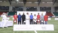 Minister of Sports and Youth H E Salah bin Ghanim Al Ali (centre) with players and referees after the final.