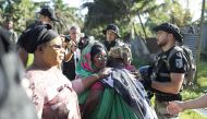 People react during the demolition of an informal settlement in Langoni, Mamoudzou, on the island of Mayotte on April 27, 2023. (Photo by Patrick Meinhardt / AFP)