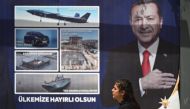 A woman walks past a billboard with the portrait of Turkish President Recep Tayyip Erdogan in Sanliurfa, south-eastern Turkey on April 28, 2023. (Photo by OZAN KOSE / AFP)