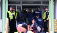 City officials and police are seen entering a a former Russian high school in Warsaw, Poland on April 29, 2023. Photo by Jaap Arriens / AFP
