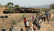File Photo: Villagers return from a market to Yechila town in south central Tigray walking past scores of burned vehicles, in Tigray, Ethiopia, July 10, 2021. (REUTERS)