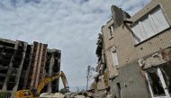 Workers dismantle a heavily damaged residential building in Irpin, on May 4, 2023, amid the Russian invasion of Ukraine. (Photo by Genya Savilov / AFP)