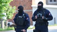 Masked policemen secure an area in the village of Dubona near the town of Mladenovac, about 60 kilometres (37 miles) south of Serbia's capital Belgrade, on May 5, 2023, in the aftermath of a drive-by shooting. Photo by ANDREJ ISAKOVIC / AFP