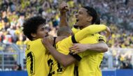 Dortmund's Dutch forward Donyell Malen (C) is congratulated by Dortmund's German forward Karim Adeyemi (L) and Dortmund's French forward Sebastien Haller (R) after scoring the 1-0 goal during the German first division Bundesliga football match between BVB Borussia Dortmund and Borussia Moenchengladbach in Dortmund, western Germany on May 13, 2023. (Photo by INA FASSBENDER / AFP) 
