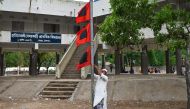 A man raises a storm danger signal flag in Teknaf on May 13, 2023, ahead of Cyclone Mocha's landfall. (Photo by Munir uz zaman / AFP)