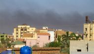 Smoke rises behind buildings in Khartoum amid ongoing fighting between the forces of two rival generals, on May 16, 2023. Photo by AFP