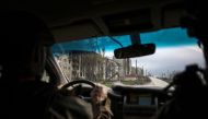  Ukrainian serviceman drives a car down a street near residential buildings damaged by shelling in the frontline city of Bakhmut, Donetsk region, on April 23, 2023, amid the Russian invasion of Ukraine.   (Photo by Anatolii Stepanov / AFP)