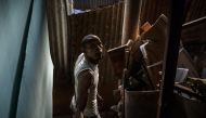 A man looks up as he dismantles his makeshift house in a shantytown of 