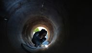 A labourer works at a construction site in Chennai on May 22, 2023. (Photo by R.Satish Babu / AFP)