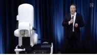 This video grab made from the online Neuralink livestream shows Elon Musk standing next to the surgical robot during his Neuralink presentation on August 28, 2020.(Photo by Neuralink / AFP) 