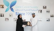 Nasser Al Sharshani, General Manager of Uber Qatar (right) with Mona Ashkanani - Director General of Qatar Cancer Society.