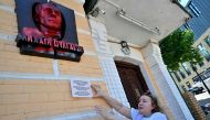 The museum's director Lyudmyla Gubianuri shows the plaque depicting Mikhail Bulgakov, the author of 