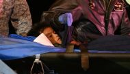 One of the four Indigenous children is stretchered out of a plane upon landing at the CATAM military base in Bogota on June 10, 2023. (Photo by Juan Barreto / AFP)