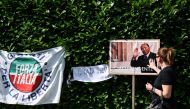 A mourner touches a picture of Italian businessman and former prime minister Silvio Berlusconi, during a tribute following his death, outside of his residence Villa San Martino, in Arcore, northern Italy, on June 12, 2023. (Photo by GABRIEL BOUYS / AFP)

