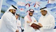 QU President Dr. Hassan Al Derham skims through a book at the QU pavilion.