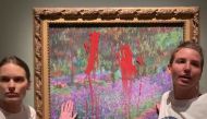 This handout video grab taken from footage provided by action network Aterstall Vatmarker on June 14, 2023 shows two activists standing next to the painting 