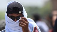 File photo: A man uses a scarf to shelter from the heat during a hot day in New Delhi on April 19, 2023. (Photo by Arun SANKAR / AFP)