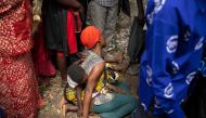 A woman mourns during the funeral of Florence Masika and Zakayo Masereka in Mpondwe in western Uganda, on June 18, 2023. (Photo by Stuart Tibaweswa / AFP)