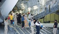 Evacuees alight from a Qatari airplane from Sudan as part of Qatar's air bridge support for the Sudanese people.