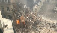 This photograph taken on June 21, 2023, shows the flames emerging from the destruction and rubble in the immediate aftermath of an explosion in a building on Rue Saint-Jacques near Place Alphonse-Laveran in the 5th arrondissement of Paris. Photo by Gregory Custo / AFP


