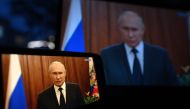 This photograph shows Russia's President Vladimir Putin, seen on a smartphone screen and a laptop screen, making a statement in Moscow, on June 26, 2023. (Photo by NATALIA KOLESNIKOVA / AFP)