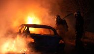 French firefighters extinguish burning vehicles following protests in Nanterre, west of Paris, on June 28, 2023, a day after a 17-year-old boy was shot in the chest by police at point-blank range in this western suburb of Paris. (Photo by Zakaria ABDELKAFI / AFP)
