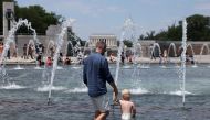 
Visitors and tourists to the World War II Memorial seek relief from the hot weather in the memorial's fountain on July 3, 2023 in Washington, DC. (Photo by Kevin Dietsch/Getty Images via AFP)