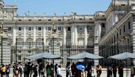 Tourists protect themselves of the sun while they visit the Royal Palace in Madrid city centre under very high temperatures, on June 26, 2023 as Spain is facing its first heatwave of the summer, with temperatures expected to exceed 44 degrees locally in the south of the country. Photo by Thomas Coex / AFP