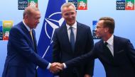 Turkish President Tayyip Erdogan (left) and Swedish Prime Minister Ulf Kristersson shake hands in front of NATO Secretary-General Jens Stoltenberg prior to their meeting, on the eve of a NATO summit, in Vilnius on July 10, 2023. (Photo by YVES HERMAN / POOL / AFP)