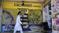 A man walks past foreign currency exchange market in Islamabad on July 11, 2023. (Photo by Aamir Qureshi / AFP)