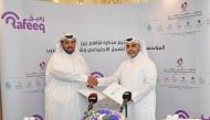 In charge of the duties of the CEO of Qatar Social Work Rashid bin Mohammed Al Hamda Al Nuaimi and CEO of Rafeeq Abdullah Thamer Al Hamidi exchanging documents after signing the agreement.