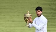 Spain's Carlos Alcaraz raises the winner's trophy after beating Serbia's Novak Djokovic during their men's singles final tennis match on the last day of the 2023 Wimbledon Championships at The All England Tennis Club in Wimbledon, southwest London, on July 16, 2023. (Photo by SEBASTIEN BOZON / AFP)