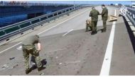 This video grab taken and released on July 17, 2023 by the Russian Investigative Commitee shows committee investigators working on the Kerch bridge -- linking Crimea to Russia -- which was heavily damaged following an attack. (Photo by Russian Investigative Commitee / AFP) 
