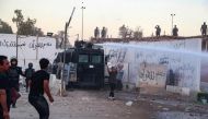 Iraqi riot police use water cannon to disperse supporters of Iraqi Shiite cleric Moqtada al-Sadr gathering for a protest outside the Swedish embassy in Baghdad on July 20, 2023. Photo by Ahmad AL-RUBAYE / AFP