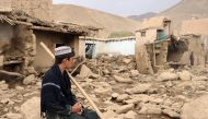 An Afghan resident sits next to his house that was damaged in flash floods in the Jalrez district of Maidan Wardak province on July 23, 2023. (Photo by AFP)
