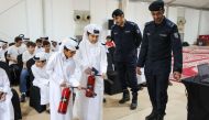 Children being trained on how to use a fire extinguisher.